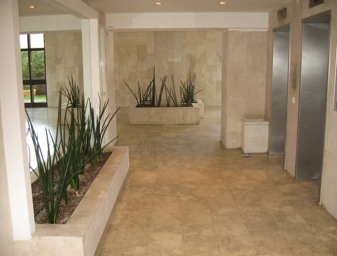 A clean, high-gloss commercial building lobby with a polished stone-tile floor.
